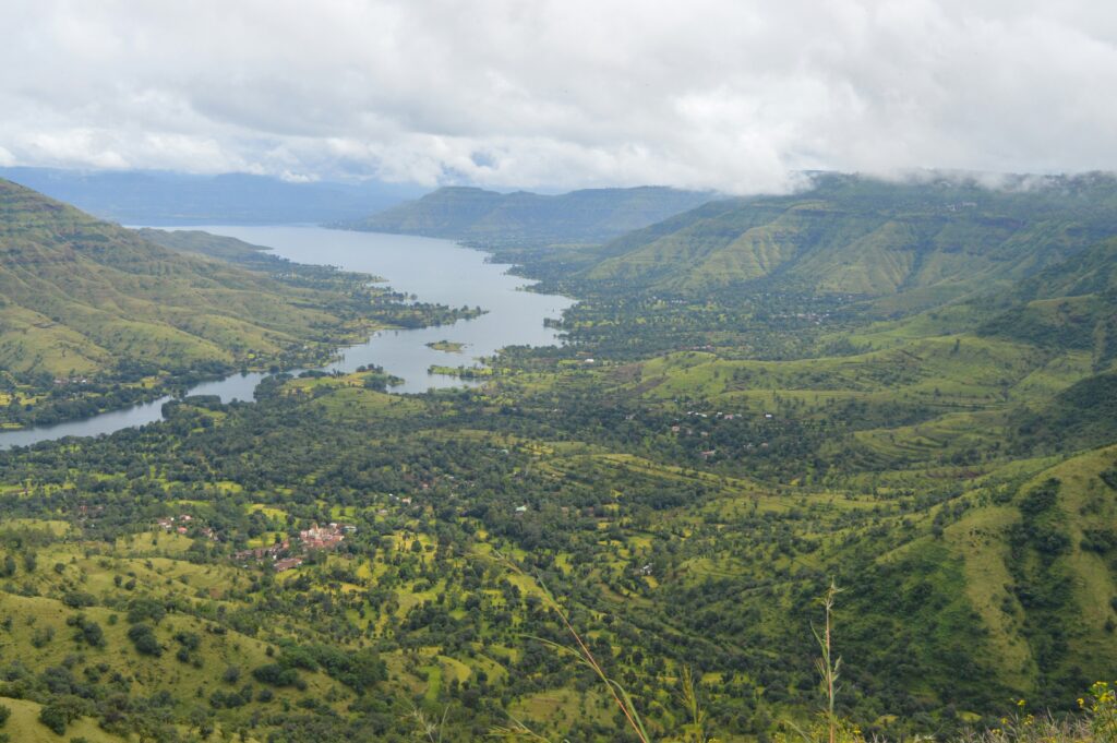 Panoramic view of lush green valleys and a serene lake near Lonavala – a popular weekend getaway destination close to Mumbai and Pune, perfect for villa stays with Aaramghar Stays.